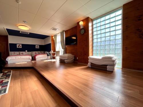 a living room with a wooden floor and a large window at 九十九里 SURF SIDE DOGRUN HOUSE in Katakai