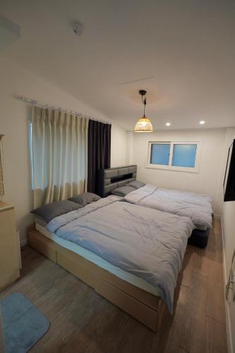 a bedroom with two beds and a chandelier at Soo Guest House in Seoul
