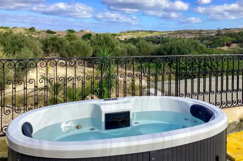 una vasca idromassaggio su un balcone recintato di Pleasant stone house & jacuzzi St Martin - Happy Rentals a Mġarr