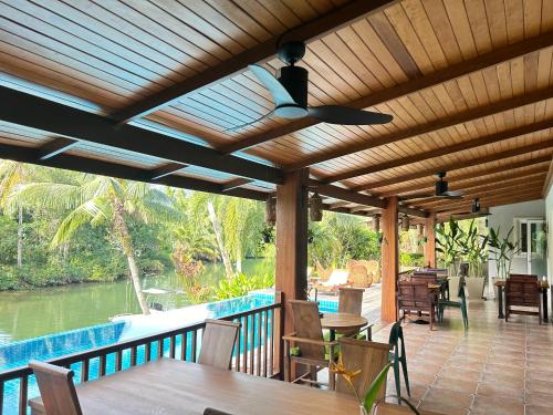 eine hölzerne Pergola mit einem Tisch und Stühlen auf einer Terrasse in der Unterkunft Nanai Resort Salakphet in Ko Chang