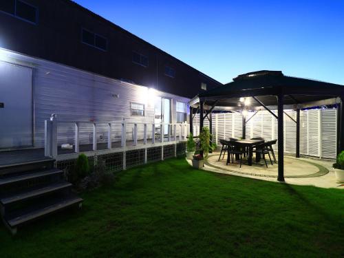 a patio with a table and an umbrella at 九十九里 SURF SIDE DOGRUN HOUSE in Katakai