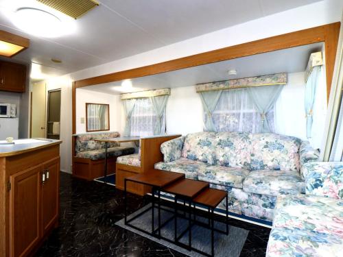 a bedroom with a bed and a couch and a table at 九十九里 SURF SIDE DOGRUN HOUSE in Katakai