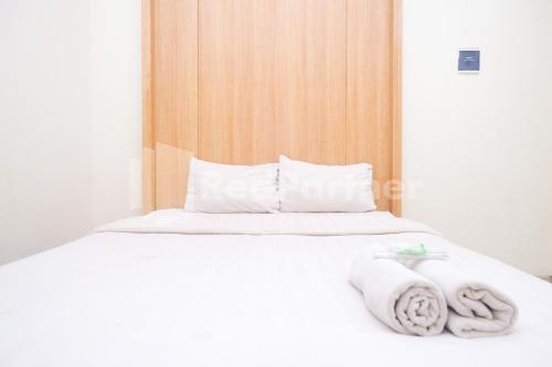 Una cama con sábanas blancas y toallas. en Garuda Guesthouse Yogyakarta RedPartner, en Yogyakarta
