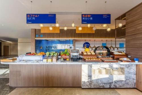 Holiday Inn Express Yuhuan Wetland Park by IHG في Yuhuan: مطعم عليه كونتر عليه طعام
