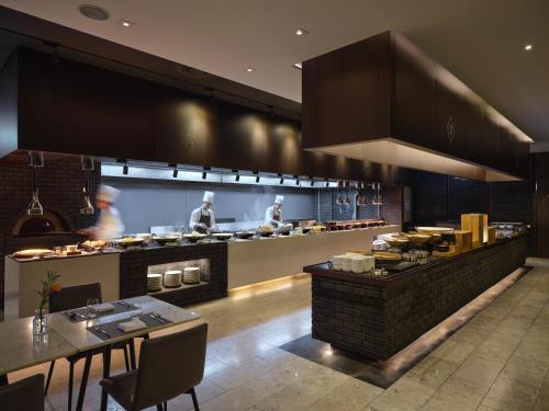 a restaurant with a kitchen with people preparing food at GLAD Yeouido in Seoul