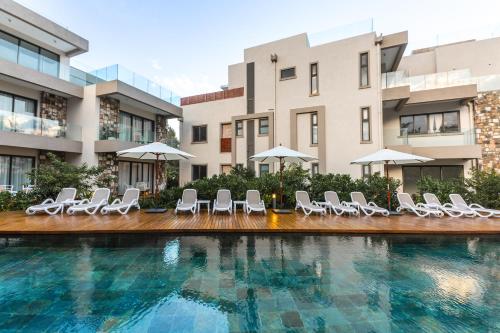 una piscina con sillas y sombrillas frente a los edificios en Apartment Beachfront Ocean Terraces Residence, Poste Lafayette-Apt-C4, en Poste Lafayette