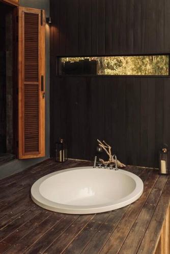 a bathroom with a white tub on a wooden floor at Secret Window Residency in Ban Kat Hao