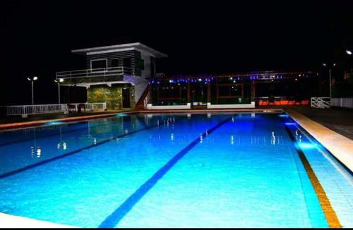 ein großer Swimmingpool in der Nacht mit einem Gebäude in der Unterkunft OLAYN RESORT in Tagaytay