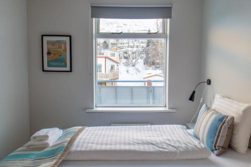 una camera con un letto di fronte a una finestra di Hildibrand Apartment Hotel a Neskaupstaður