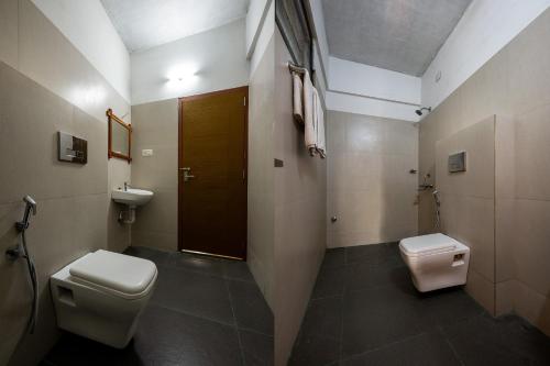 a bathroom with a toilet and a sink at CJ GRANDE BUSINESS HOTEL in Ernakulam