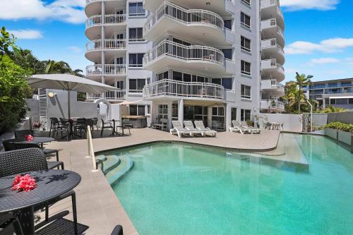 a large apartment building with a swimming pool at Beachside Resort Kawana Waters in Buddina