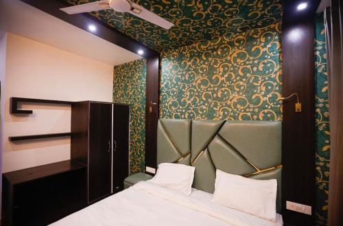 a bedroom with a bed with a green and gold wallpaper at Seven Hills Resort Srinagar By Him Haults Hospitality in Srinagar