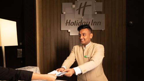 a man in a suit shaking hands with a woman at Holiday Inn New Delhi International Airport, an IHG Hotel in New Delhi