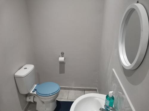 a white bathroom with a toilet and a sink at Amapondo Backpackers Lodge in Port St Johns