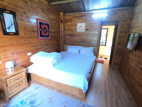 a bedroom with a bed in a wooden cabin at Amica House in Sa Pa