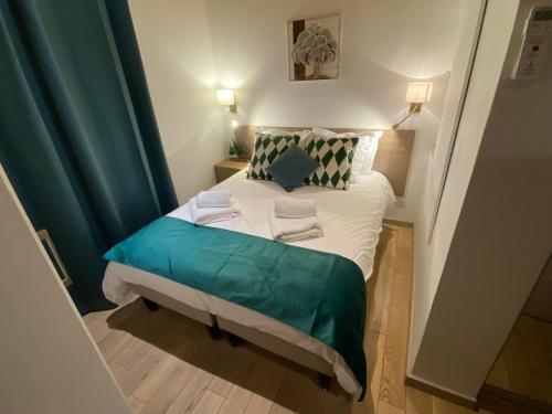 a small bed in a small room with green curtains at Relais Des Alpes in Guillaumes