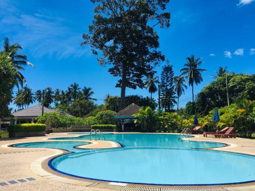 - une piscine dans un complexe avec des palmiers dans l'établissement Suan Bankrut Beach Resort, à Ban Krut