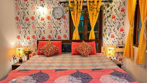 a bedroom with a bed with red pillows at Dreamy Boho Haven in Vagator