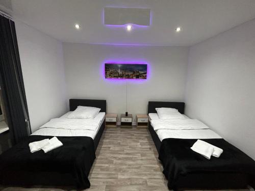 2 camas en una habitación con techo púrpura en Wellness Suite mit Whirlpool und Sauna en Gelsenkirchen