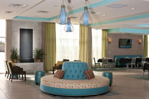 um átrio com um sofá azul e mesas e cadeiras em Holiday Inn Guin, an IHG Hotel em Yampertown