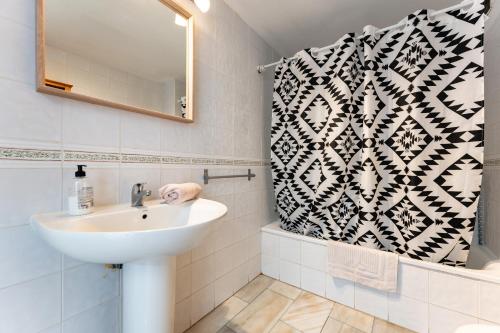 Un baño con lavabo y cortina de ducha. en Superbly situated Vistamar, en Mijas Costa