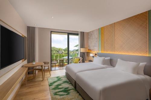 a hotel room with two beds and a television at Dusit Princess Phatthalung in Phatthalung
