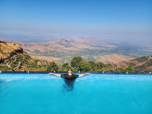 a woman is standing in a pool of water at Hilltop Resort and Glamping Wai, Near Panchgani in Wai