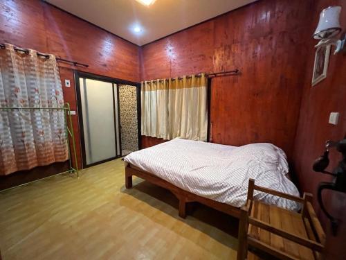 a bedroom with a bed in a wooden wall at Aya House in Pai