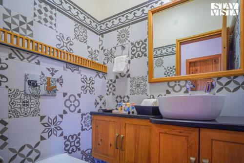 W łazience znajduje się umywalka i lustro. w obiekcie StayVista at Wandering Hills w mieście Palampur