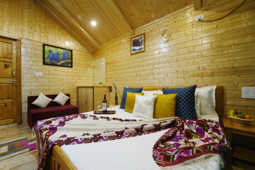 a bedroom with a large bed in a wooden room at Tree house Latos Tandi in Jibhi