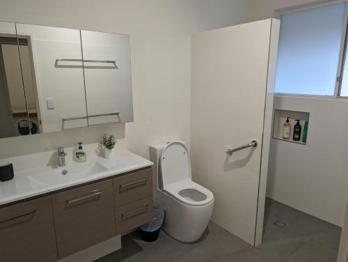 een badkamer met een toilet, een wastafel en een spiegel bij Spacious, Modern & Stylish Vacation Home in Seaton