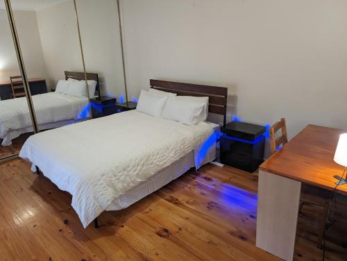 een slaapkamer met 2 bedden en een bureau met een bureau bij Spacious, Modern & Stylish Vacation Home in Seaton