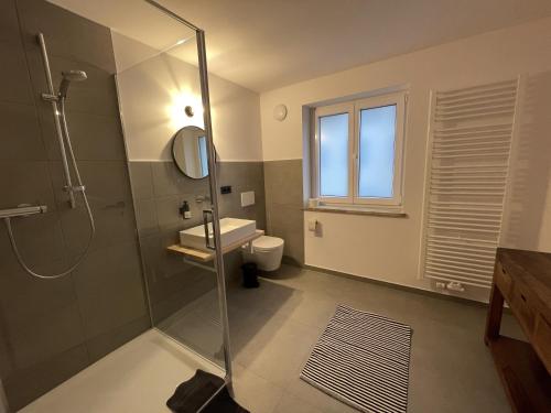 a bathroom with a shower and a sink and a toilet at Alte Seifensiederei - Fabienne in Bad Tölz