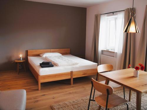 Dormitorio pequeño con cama y mesa en Alte Seifensiederei - Thay en Bad Tölz
