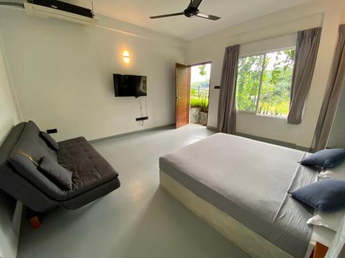 1 dormitorio con 1 cama, 1 silla y TV en Sesatha lake Kandy en Kandy