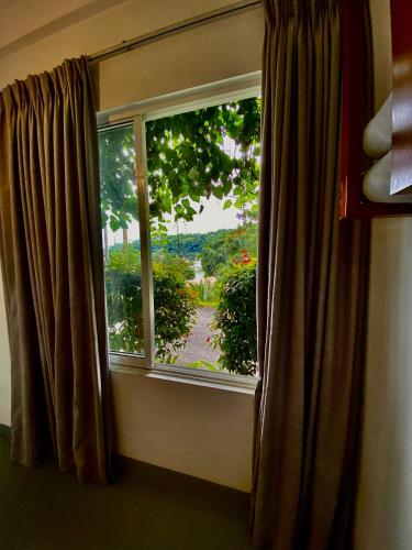 a window with a view of a garden outside at Sesatha lake Kandy in Kandy