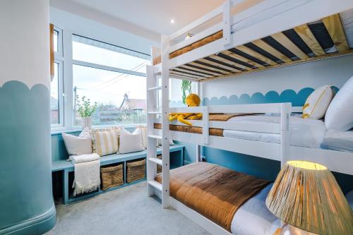 a kids room with bunk beds and a window at Cabin Hill in Colwyn Bay