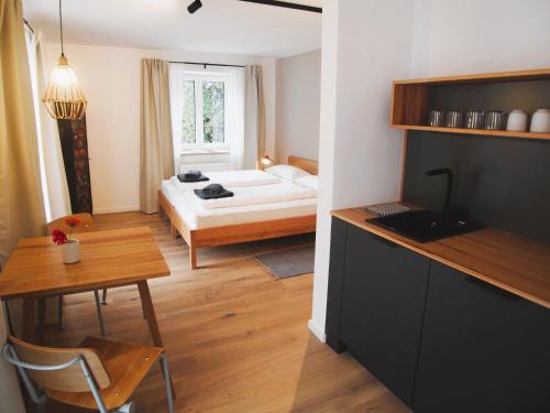 um pequeno quarto com uma cama e uma mesa com uma mesa de sidx em Alte Seifensiederei - Viktor em Bad Tölz