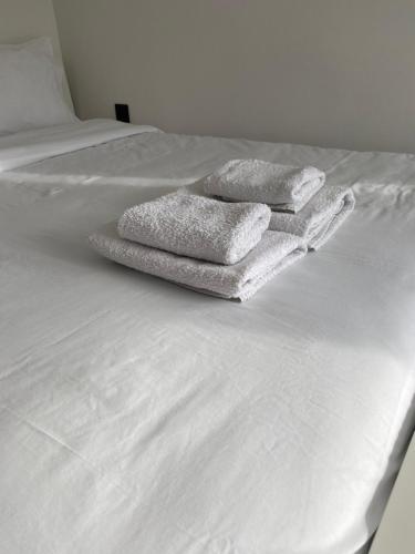 two towels sitting on top of a white bed at Seaview by Agora Flats in Thessaloniki