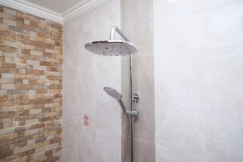 La salle de bains est pourvue d'une douche avec un pommeau de douche. dans l'établissement Urbanview Syariah Loji Arum Stasiun Klaten by RedDoorz, à Klaten