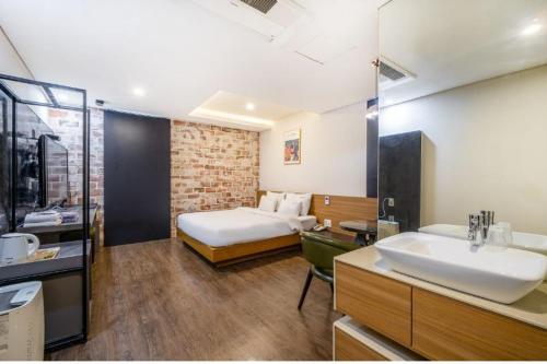 - une chambre avec un lit et une salle de bains pourvue d'un lavabo dans l'établissement Stay 247, à Gimhae