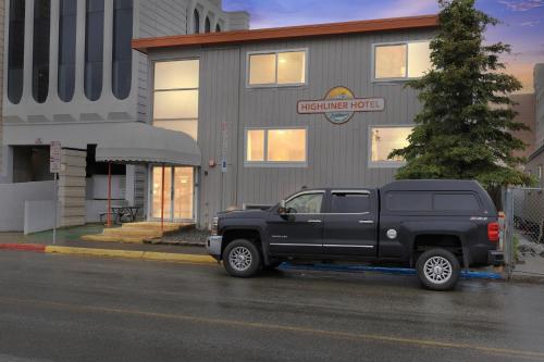 a black truck parked in front of a building at Highliner Hotel- King Suite 110 Hotel Room in Anchorage