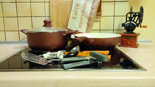 a pot on a stove with a bunch of kitchen utensils at Warsaw Modlin 70m2 Apartment in Nowy Dwór Mazowiecki