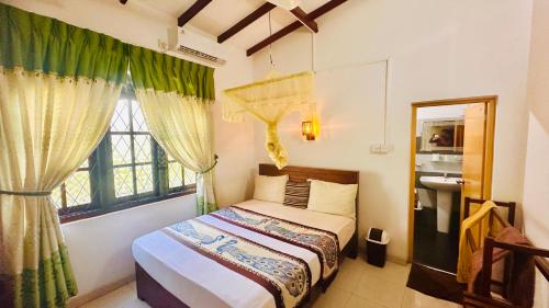 a bedroom with a bed and a window at New Peacock Resort in Dambulla