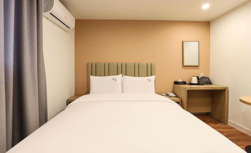 a bedroom with a large white bed in a room at Hotel Daon in Pohang