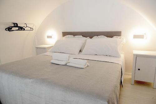 ein weißes Bett mit zwei Handtüchern darüber in der Unterkunft Donna Anna in Polignano a Mare