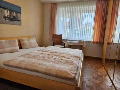 Schlafzimmer mit einem Bett, einem Tisch und einem Fenster in der Unterkunft Ferienhaus Wellsandt in Norderney