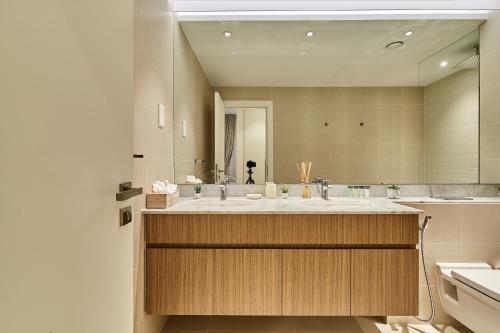 a bathroom with a large sink and a large mirror at Majestic La MER La Voile1 - Jumeirah 1- Swimming pool view in Dubai