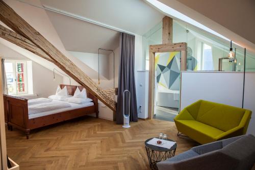 a bedroom with a bed and a green chair at Niedermairhof in Brunico