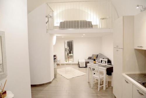 a white living room with a kitchen and a dining room at Donna Anna in Polignano a Mare